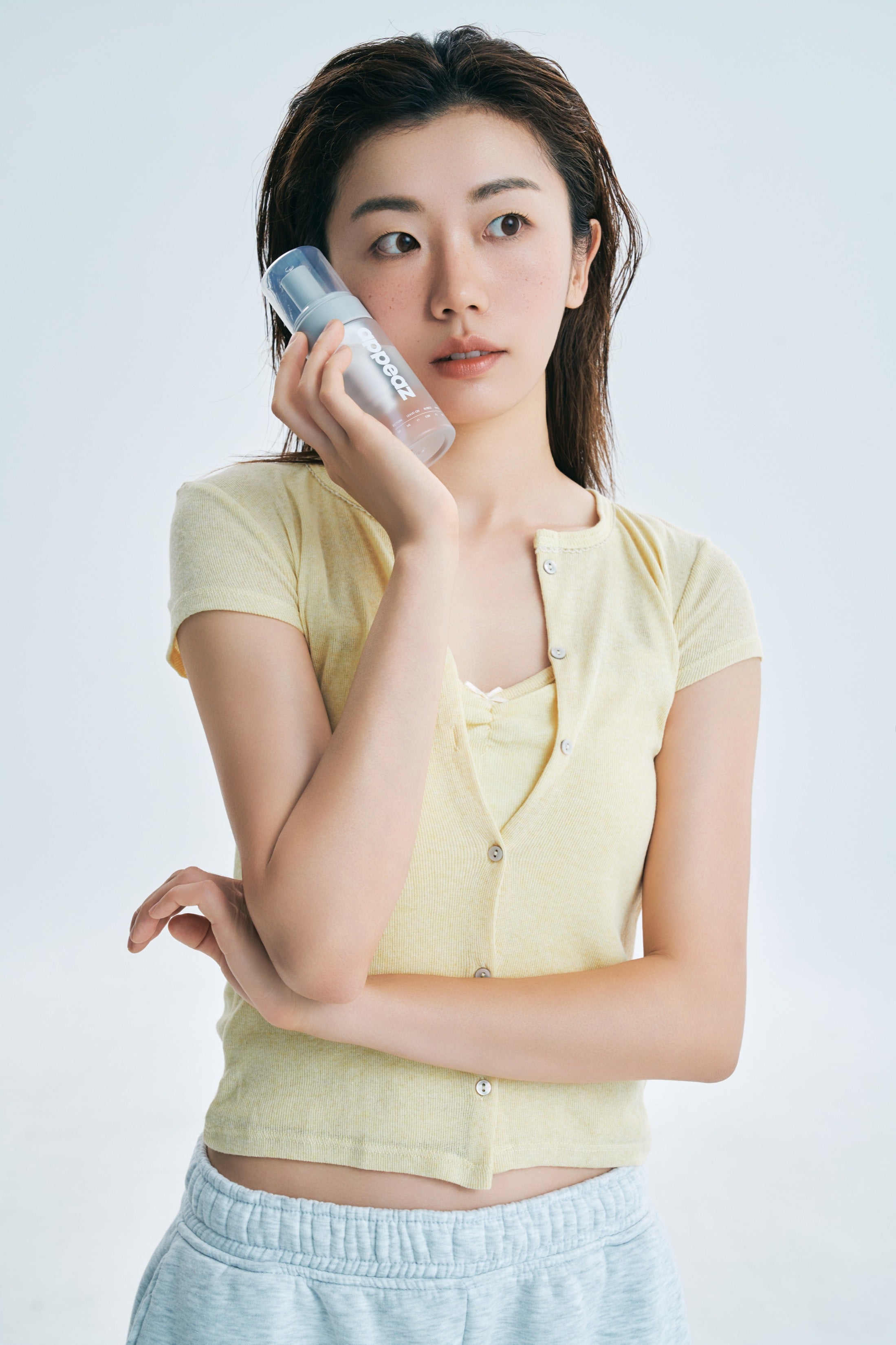 model resting an appeaz foam bottle against her cheek