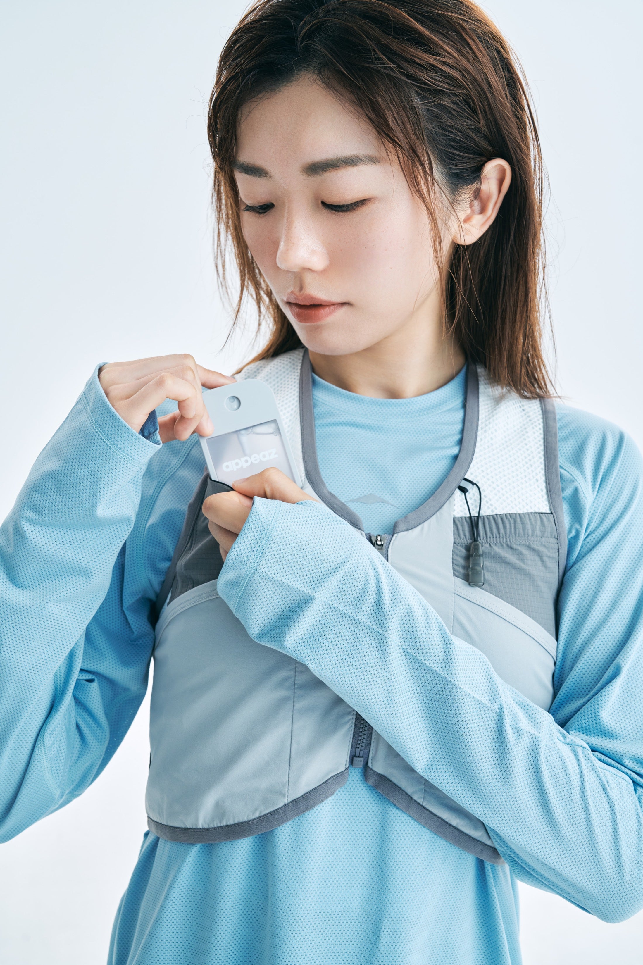 model taking an appeaz stick from the pocket of a running vest